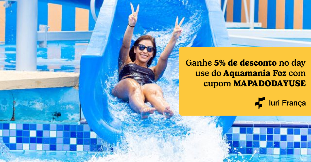 Foto de uma mulher descendo um escorregador azul. No canto lateral direito tem uma tag amarela com o texto "Ganhe 5% de desconto no day use do Aquamania Foz com cupom MAPADODAYUSE"